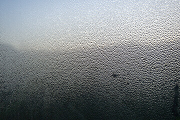 Wet, foggy glass. Drops of water on the window, rain, condensation.