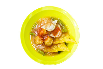 Top view of Thai Style Noodle with assorted tofu and fish ball in Red Soup in yellow bowl, focus selective