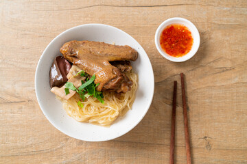 dried noodles with braised duck in white bowl