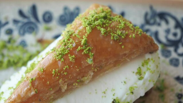 Delicious Baklava Dessert with Pistachio and Cream on a plate looks appetizing and mouthwatering