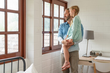 Happy father young man and little daughter having fun in children room at home. Young smiling dad is playing with his girl. Dad and little girl. Full length carefree two generations family having fun.