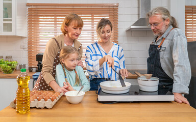 Family morning at home. Happy father, mother and sister and sister enjoying time together while having healthy breakfast. Family cooking at home together	