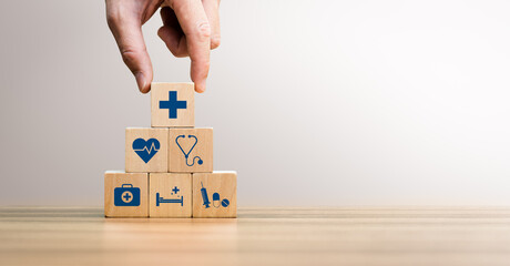 Health insurance concept, Hand Arranging Wooden Blocks with Medical Icons Including Heartbeat, Stethoscope, Syringe, and Healthcare Cross Symbol, Future Healthcare Technology