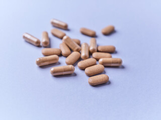 Ashwagandha (Withania somnifera) tablets and capsules on paper background. Soft focus.. Close up. Copy space.	