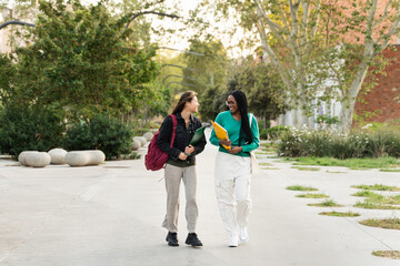 Cheerful University student girl friends talking and walking going to College School