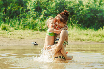 Fototapeta premium mom and child swim in the river