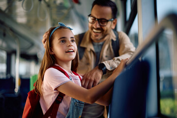 Little girl commuting with her father by bus.
