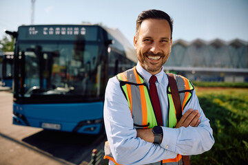 Happy driver at bus station looking at camera.