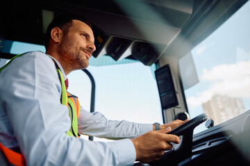Below view of bus driver behind  steering wheel. © Drazen