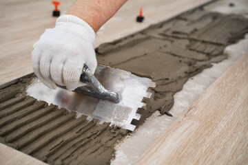 Laying tiles concept. Tiler, spatula and glue when laying tiles. Pull tabs and wedges for leveling...