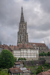 Naklejka premium tourist go to travel walk in walking street see old building architecture nation flag and clock tower in Bern Switzerland spring season