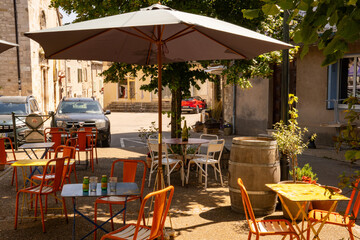 Restaurant with colorful tables and chairs and a parasol on the terrace on the church square of Sault, Provence-Alpes-Côte d'Azur, France © Sandra Alkado