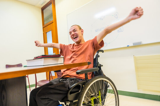 Happy man with disability celebrating in the university