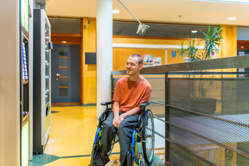 Disabled man looking into vending machine in a coworking