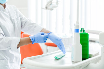 Obraz premium Dentist Putting On Blue Medical Gloves