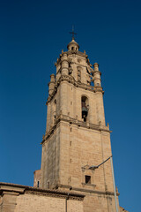 Detail plan of the bell tower of the medieval stone church of the tourist village of Los Arcos in Navarre, with the blue sky in the background.