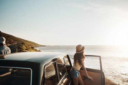 Car, travel and couple with view at beach for summer vacation, anniversary and sunset in Norway. Holiday, drive and woman by ocean on road trip for tourism, romantic adventure and outdoor sightseeing
