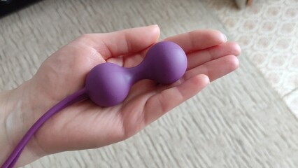 Young woman holds a dildo in her hand