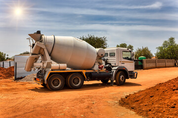 concrete mixer trucks on a dirt road on construction site