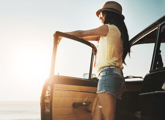 Road trip, happy and woman in car by ocean on holiday, vacation and summer weekend in countryside. Travel, lens flare and person in vehicle by seaside for transport, journey and driving adventure