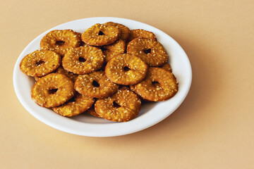 Round crackers with a hole and salt on an orange background