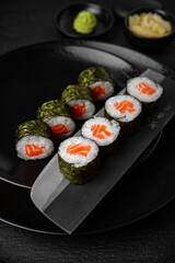 Salmon Maki. Sushi composition on black background. The Art of Japanese Cuisine. Food photography for menu and sushi bar decoration