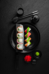 Rainbow Roll. Sushi composition on black background. The Art of Japanese Cuisine. Food photography for menu and sushi bar decoration