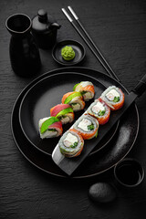 Rainbow Roll. Sushi composition on black background. The Art of Japanese Cuisine. Food photography for menu and sushi bar decoration