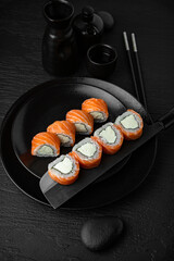 Philadelphia Cheese Roll. Sushi composition on black background. The Art of Japanese Cuisine. Food photography for menu and sushi bar decoration