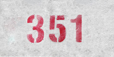 Red Number 351 on the white wall. Spray paint.