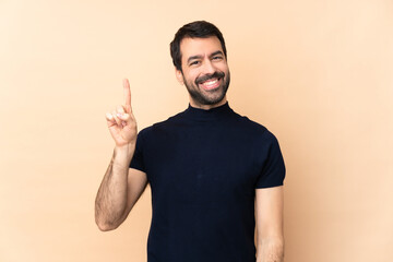 Caucasian handsome man over isolated background showing and lifting a finger in sign of the best