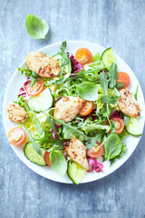 Salad with Chicken Breast, Cherry Tomatoes, Cucumber, Rocket and fresh Basil. Bright wooden background. Close up.	