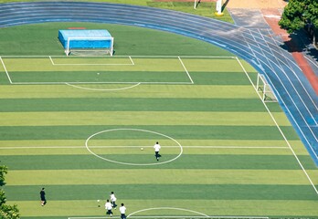 Obraz premium Aerial view over a soccer field with players playing on a sunny day