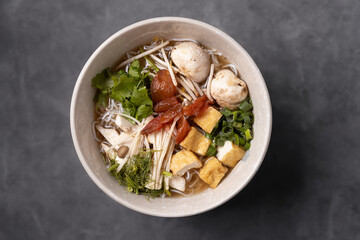Asian tofu soup served in bowl on dark background. 