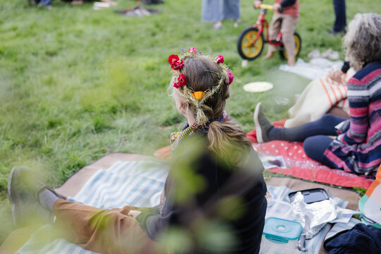 A woman wearing a floral wreath for a celebration of Midsummer Day of a Waldorf school.