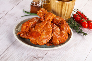 Raw turkey shoulder wing in Indian tandoori marinade