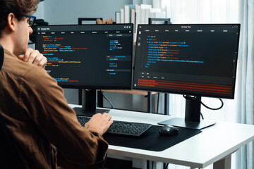 IT developer working online software development on pc monitors at modern home office on coding...
