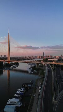 Aerial view of Ada Bridge on Sava River at beautiful sunset. Cinematic Vertical video.