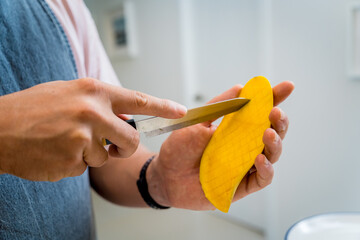 Chef at the kitchen preparing bowl of oats with strawberries and mango
