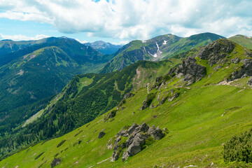 Fototapeta premium Beautiful mountain landscape in summer. Green grass, high rocks, blue sky and white clouds. Natural background. Tatra Mountains