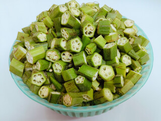 Sliced lady's fingers okra heap in bowl green lady finger bhindi vegetable food seedpods vegfood gombo okro damen-finger quimbombo quiabo bhindee abelmoschus esculentus image green bhindi photo.