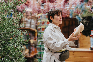 Fototapeta premium Woman exploring a vibrant market with lush greenery and colorful decorations, holding a wooden shoe in her hands.