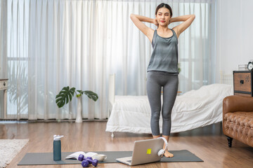 Fototapeta premium Portrait sport asian beauty body slim woman in sportswear sitting relax and girl practicing yoga and do fitness exercise with laptop computer in bedroom at home.Diet concept.Fitness and healthy