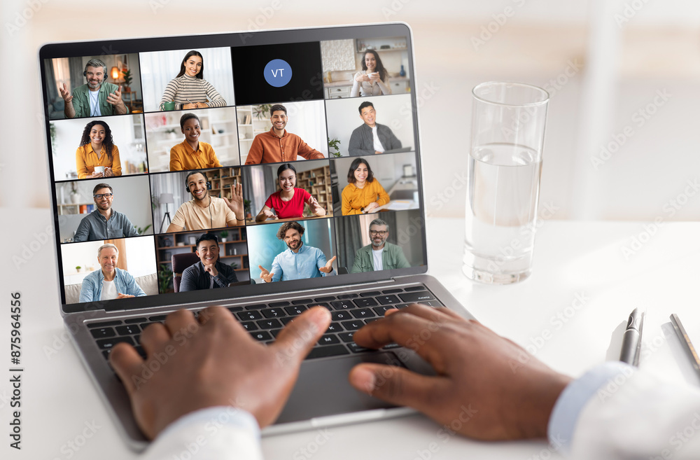 Poster A persons hands are visible typing on a laptop while a virtual meeting with several participants is displayed on the screen. Experience of virtual communication, collaboration in the modern workplace.