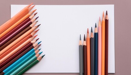 Top view of a blank white paper sheet with vibrant colored pencils lined up beside it.