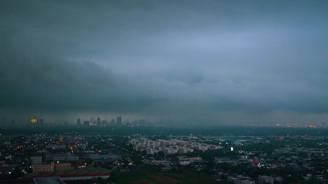 Lightning strikes and flashes squall. Dark clouds release tropical heavy downpour over cityscape, signaling sudden rainstorm. Motion timelapse weather