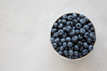 Organic Blueberries in a Bowl on a gray background, top view. Flat lay, overhead, from above. Copy space.