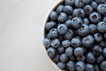 Organic Blueberries in a Bowl on a gray background, top view. Flat lay, overhead, from above. Copy space.