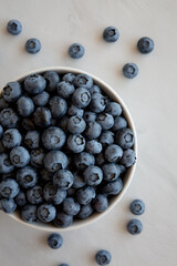 Organic Blueberries in a Bowl on a gray background, top view.