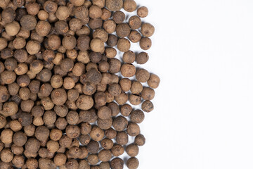 Black peppercorns close-up top view on white background, copy space for text